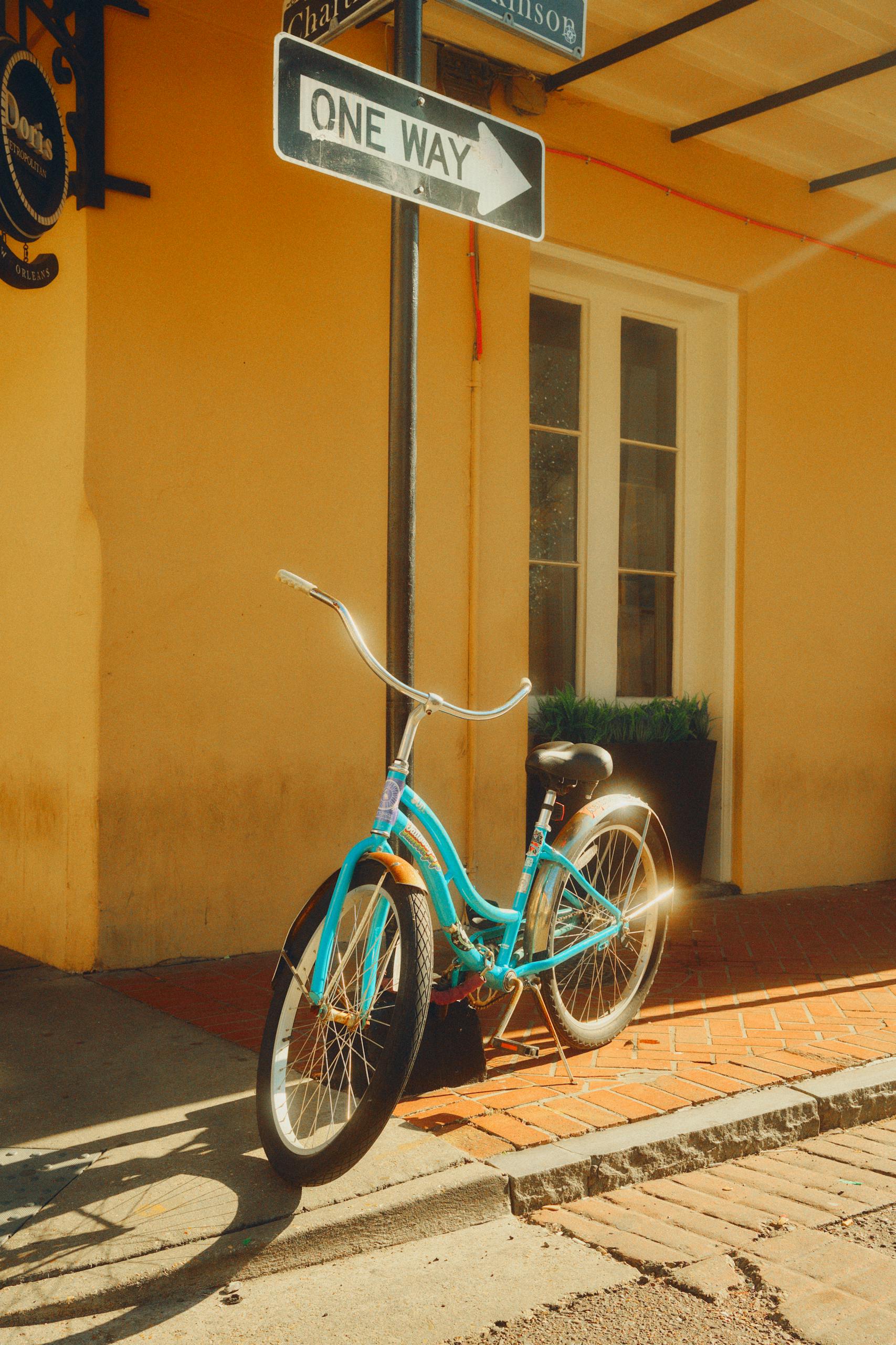 Vintage bicycle against a sunny New Orleans street corner, featuring warm tones.